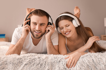 Poster - Happy young couple listening to music in bedroom