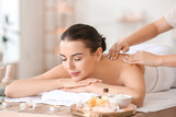 Beautiful young woman receiving massage in spa salon