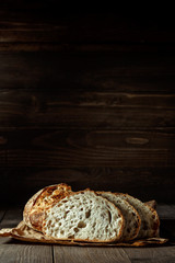 Bread, traditional sourdough bread cut into slices on a rustic wooden background. Concept of traditional leavened bread baking methods. Healthy food.