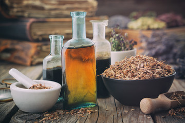 Wall Mural - healthy oak bark in bowl, infusion or tincture bottles. mortar and bowls of medicinal herbs and book