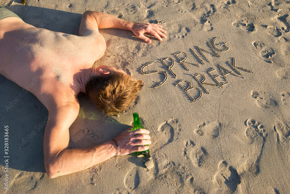 Shirtless guy passed out on the beach with beer bottle next to Spring ...