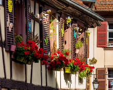 Classic Alsatian Windows In A Half-timbered House, Decorated With Wooden Carvings And Flowers