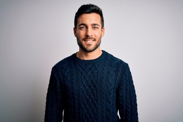 young handsome man with beard wearing casual sweater standing over white background with a happy and