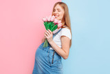 Fototapeta Tulipany - Pregnant woman with a bouquet of flowers