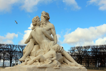 Wall Mural - Sculpture in the central park of Paris with depicted people adults and children against the sky