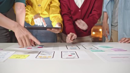 Young Asian business creative developer team work together at night, mobile application software design project. Brainstorm meeting, UI/UX technology, office coworker teamwork concept. 4K panning shot