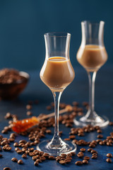 Wall Mural - Irish cream or Coffee Liqueur and coffee beans on blue background