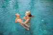 © Make_story Studio - Smiling woman with child relaxing in swimming pool. Summer vacations concept