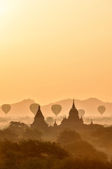 Wall Mural - Scenic and stunning sunrise with many hot air balloons over Bagan in Myanmar. Bagan is an ancient city and World Heritage Site certified by UNESCO with thousands of historic buddhist temples