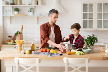 Wall Mural - Father and son cooking diner for mother