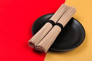 Dried Organic Buckwheat Soba Noodles Ready to Cook on red background  - Image