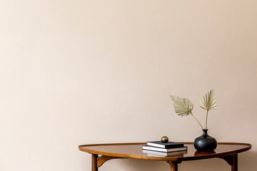 Stylish composition on the design wooden table with books and paper flowers in vase. Beige background walls. Minimalistic conept of living room. Copy space. Template. 