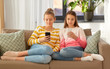 © Syda Productions - people, technology and friendship concept - teenage girls with smartphones sitting on sofa at home