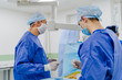 © Vadim - In surgery. Medical team performing operation in hospital operating theater. Working with surgical instruments.