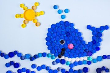 Whale mosaic decoration made of colorful plastic bottle caps. Recycling art, handmade kids craft.