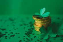 Saint Patricks Day Backdrop With Close Up Stack Of Chocolate Coins With Green Four-leafed Paper Shamrocks