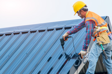 Poster - Construction worker install new roof,Roofing tools,Electric drill used on new roofs with Metal Sheet.
