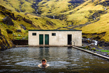 Young Boy Swims In The Seljavallalaug Geothermal Pool Located In South Iceland. This Outdoor Pool Is Free To Use And Is Filled With Naturally Heated Water.