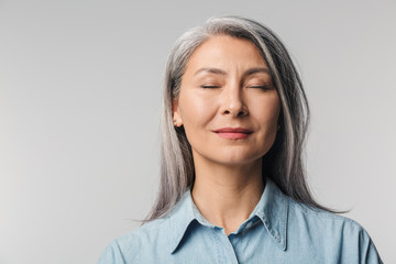 Wall Mural - Image of adult mature woman with long white hair standing with eyes closed