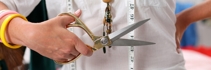 dressmaker holds sharp working scissors in hand