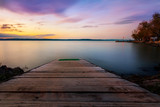 Fototapeta Pomosty - sunset on lake with a jetty in the water at Lake Balaton in Hungary,