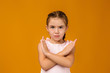 © producer - Cute little child girl making stop gesture on yellow background.