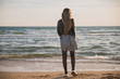 © Антон Фрунзе - a pretty girl in a plaid dress and jacket walks along the sandy beach