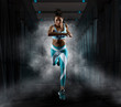© Andrey Burmakin - Sporty young woman running on smoke background