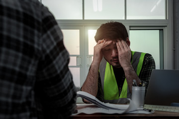 Stressful of engineer people in panic while meeting at the office, Young employee holding hands on his head with stress while sitting at the desk.