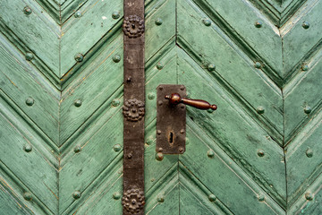 old vintage wooden decorated door with an iron frame and door handle