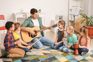 Wall Mural - Teacher giving music lessons at school