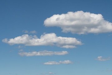 A group of white clouds almost symmetrical between the blue sky and some mountains in the south of Chile