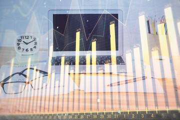 Stock market graph on background with desk and personal computer. Multi exposure. Concept of financial analysis.