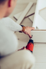 Wall Mural - Close up of a man using a drill