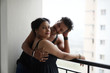 © abir - Portrait of a beautiful Indian Bengali brunette romantic couple wearing black  dresses enjoying rain while standing on the balcony. Indian lifestyle and fashion portrait