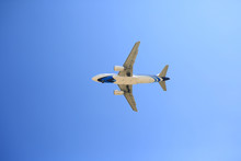 Airplane Flying On Blue Sky Background. Below View.