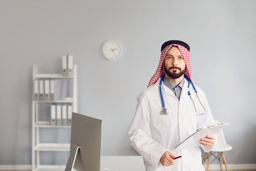 Wall Mural - Arabian male doctor pediatrician standing in the white office of the hospital.