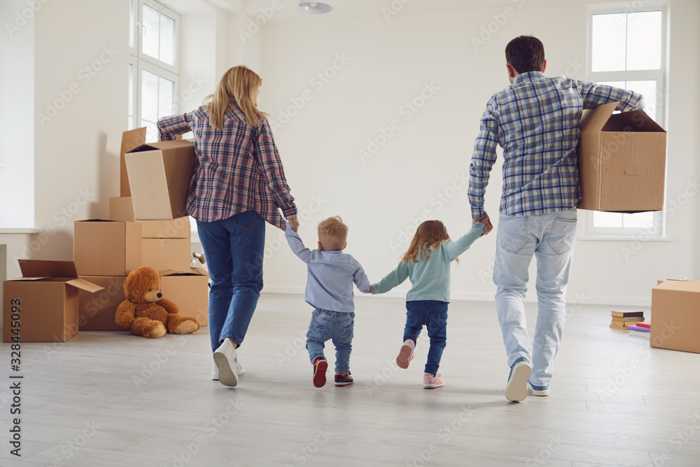 Happy family with children moving with boxes in a new apartment house. - obrazy, fototapety, plakaty 