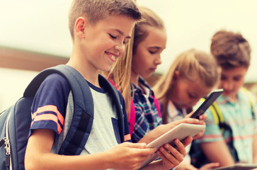 Wall Mural - primary education, friendship, childhood, technology and people concept - group of happy elementary 
