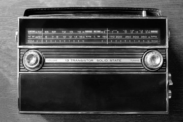 Wireless technology. An old radio on wooden background. Radio broadcasting. Musical record. Fm radio. Black and white.