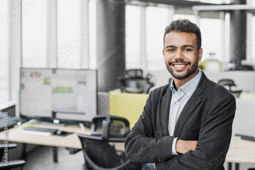Handsome young businessman with folded arms in the office Poster Mural XXL