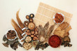 Chinese herb and spice collection  used in traditional herbal medicine on bamboo mat and mottled cream background.