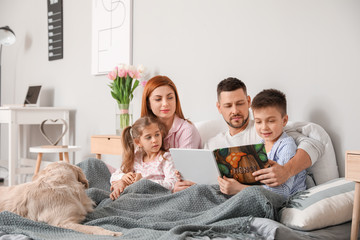 Poster - Happy family with dog reading book in bedroom at home