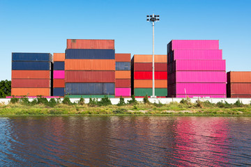 Stack of container at the riverside industrial estate area on blue sky background