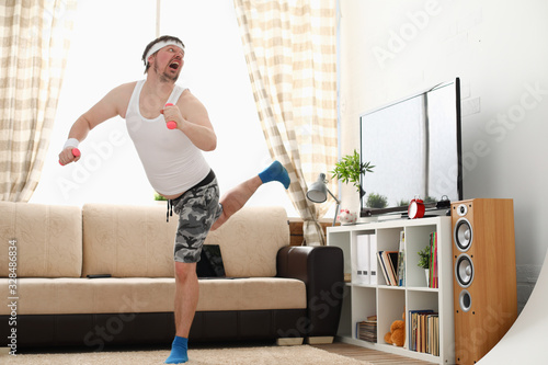 Fotomural Young handsome man in shorts and vest holds pink dumbbells in hand
