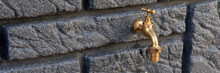 Classic Brass Faucet On The Dark Gray Stone Wall With Rectangular Structure
