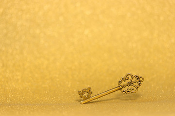 Golden vintage key on a gold background bokeh negative space