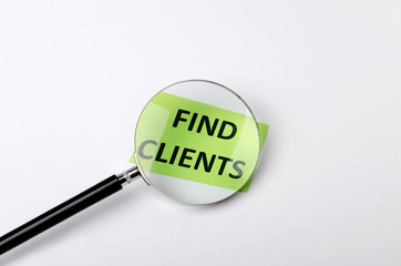 Concept of finding new ideas how to get new clints.Magnifying glass and green card with words find clients on the white background