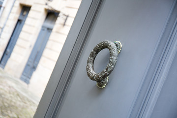 bronze grey door knocker on the facade of a French building