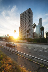 Wall Mural - Los Angeles downtown with highway and moving car. Sunrise in LA financial district